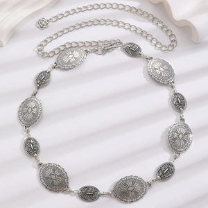 Detail showing vintage silver metal belt with sunray textures and ethnic motifs on white background