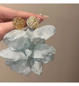 Detail of light blue chiffon flower tassel earrings with gold-tone hammered circular base