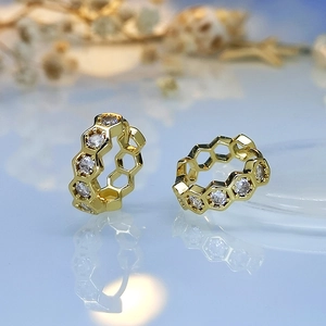 Detailed macro view of 18K gold honeycomb earrings with sparkling cubic zirconia inlay