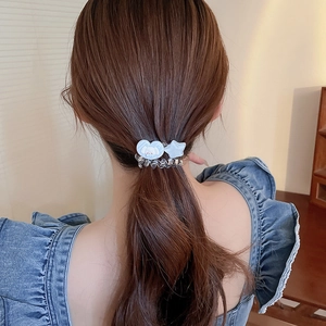 Détail d'un élastique spirale bleu clair avec charms Cinnamoroll en forme de cœur et étoile