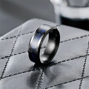 Détail macro d'une bague homme en acier titane noir avec engrenage bleu de style punk
