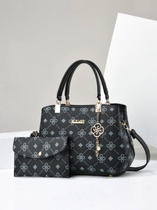 Detail view of black monogram handbag set with gold hardware and detachable strap