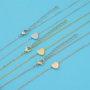 Detail of stainless steel heart pendants in silver, gold, and rose gold finishes