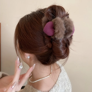 Gros plan d'une pince à cheveux en peluche marron avec cœur violet sur mannequin