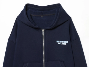 Close-up of New York print on navy blue zip-up hoodie with detailed cotton texture