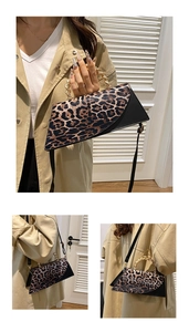 Detail of leopard print handbag with decorative gold chain handle and adjustable strap