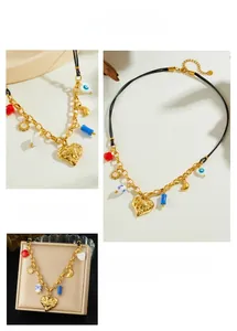 Detail of bohemian gold heart pendant necklace with evil eye charm on leather and metal chain