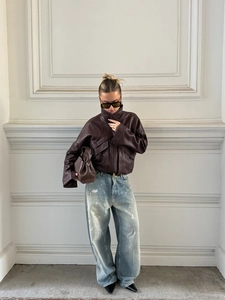 Détail de la veste en similicuir marron foncé avec texture grainée et col montant