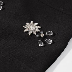 Gros plan sur les motifs de fleurs en strass étincelants sur tissu noir chic