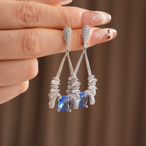Detail of vintage silver earrings with square blue zircon and teardrop crystal drops