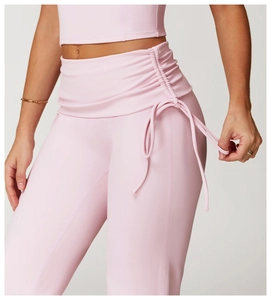 Detail of high waisted yoga pants featuring side ruched design and adjustable ties