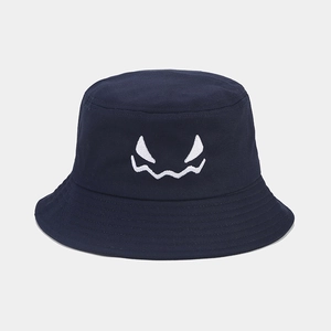 Detail of embroidered monster face with white stitching on navy cotton bucket hat