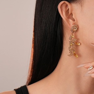 Detail of gold Chinese character earrings with rhinestones on model for a festive look