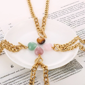 Detailed view of gold link chain necklaces with heart pendants in four stone colors