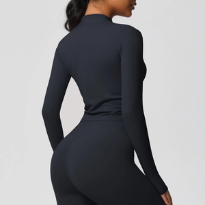 Détail d'une femme portant une veste de yoga noire à manches longues et col zippé montant