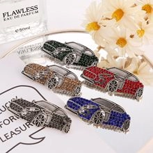Detailed view of five colorful crystal car brooches arranged on a vanity with accessories