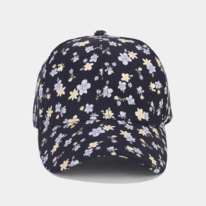 Vue détaillée des motifs floraux sur le tissu en coton bleu marine de la casquette