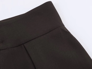 Detail of high-density twill fabric waist with neat stitching on dark brown trousers