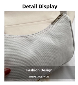 Close-up of cream corduroy baguette bag showing fine stitching and silver metal zipper