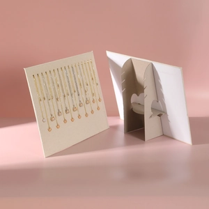 Necklace display stand with gold hooks and foldable support for jewelry presentation
