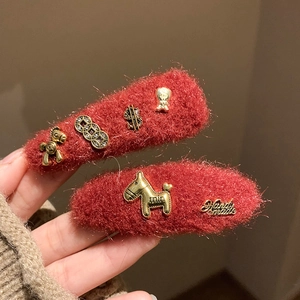 Pair of red plush hair clips with gold horse and coin charms for festive styling