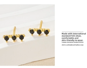 Macro view of gold-plated S925 silver stud earrings with three round black zircons