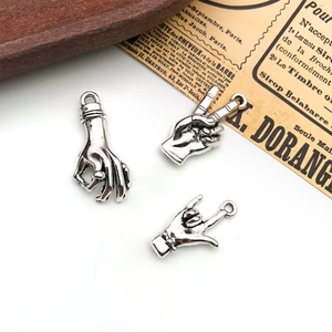 Detailed close-up of antique silver hand gesture charms for DIY jewelry making