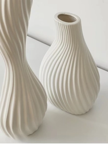 Macro detail of wave-textured white ceramic vases in modern minimalist home decor style