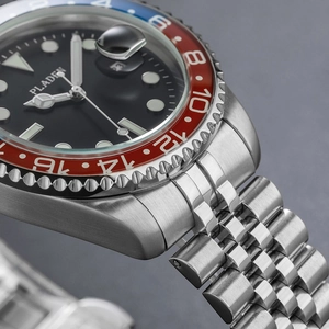 Macro detail of men's luxury steel watch with red and blue bezel and five-link bracelet