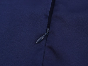 Détail de la fermeture éclair invisible et du tissu bleu marine texturé de la robe