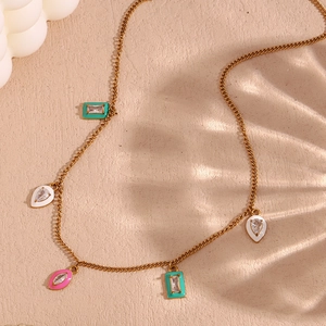 Detail of gold-plated necklace with colorful enamel charms and sparkling zircon stones