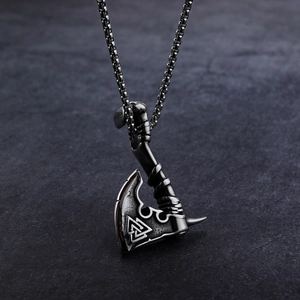 Nordic Viking battle axe pendant necklace in vintage silver steel on dark stone background