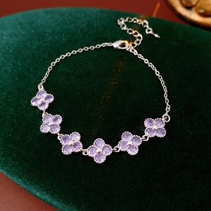 Macro shot of purple cubic zirconia flower bracelet on dark green velvet background