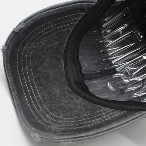 Detail of distressed baseball cap with frayed brim edges and vintage washed grey finish