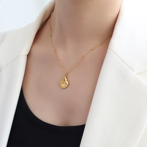 Minimalist 18k gold plated titanium steel necklace with fishtail round pendant on a model
