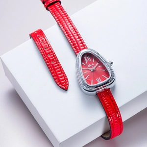 Macro shot of red snake-shaped leather strap and luxury diamond-encrusted watch bezel