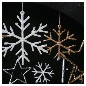 Close-up of glittery champagne gold and white snowflake ornaments for Christmas trees