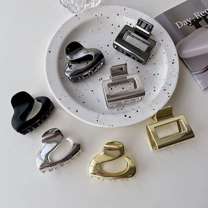 Close-up of minimalist metal hair claws in silver, gold, grey and matte black finishes