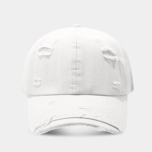 Close-up of distressed white cotton baseball cap showing ripped details and fabric texture