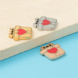 Drei spiegelpolierte Geschenkbox-Anhänger mit roten Herzen in Gold, Silber und Roségold
