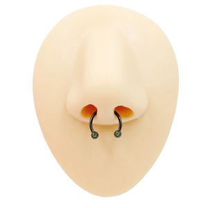 Black U-shaped horseshoe septum ring featuring vibrant green zircon stones on skin model