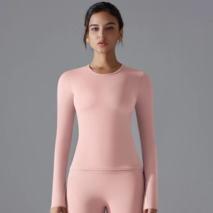 Detail of light pink long sleeve yoga top with thumbholes and breathable high-stretch fabric