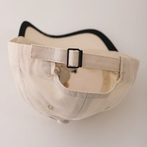 Vue arrière d'une casquette de baseball en coton beige pour bébé avec boucle en métal réglable