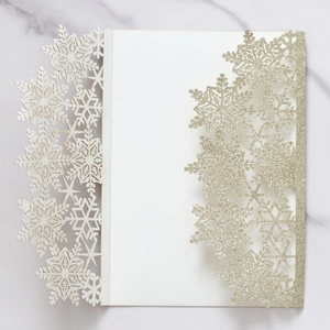 Detailed laser-cut snowflake wedding invitation with elegant silver glitter finish