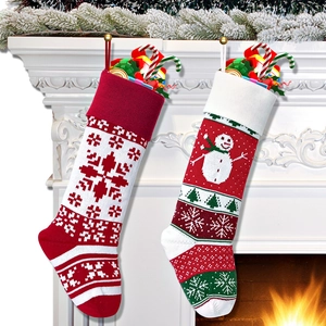 Detail of red and green knit Christmas stockings with snowflake patterns on a fireplace
