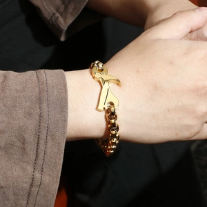 Close-up of a golden hip hop bracelet with creative hammer pendant on a male wrist