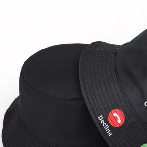 Close-up of the durable twill fabric and 'Decline' print on the black bucket hat brim