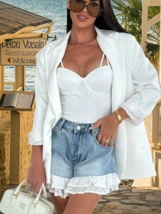 Détail du short en jean bleu clair avec bordure en dentelle blanche pour tenue d'été