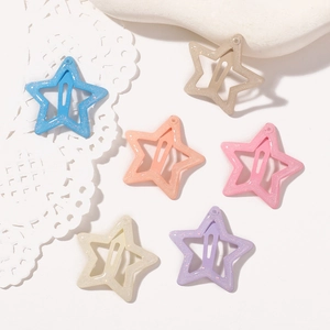Close-up of colorful star hair clips with glitter finish in macaron colors and cut-out design