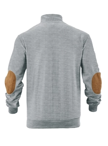 Detail of grey waffle knit sweatshirt showing brown faux suede elbow patches and ribbed cuffs